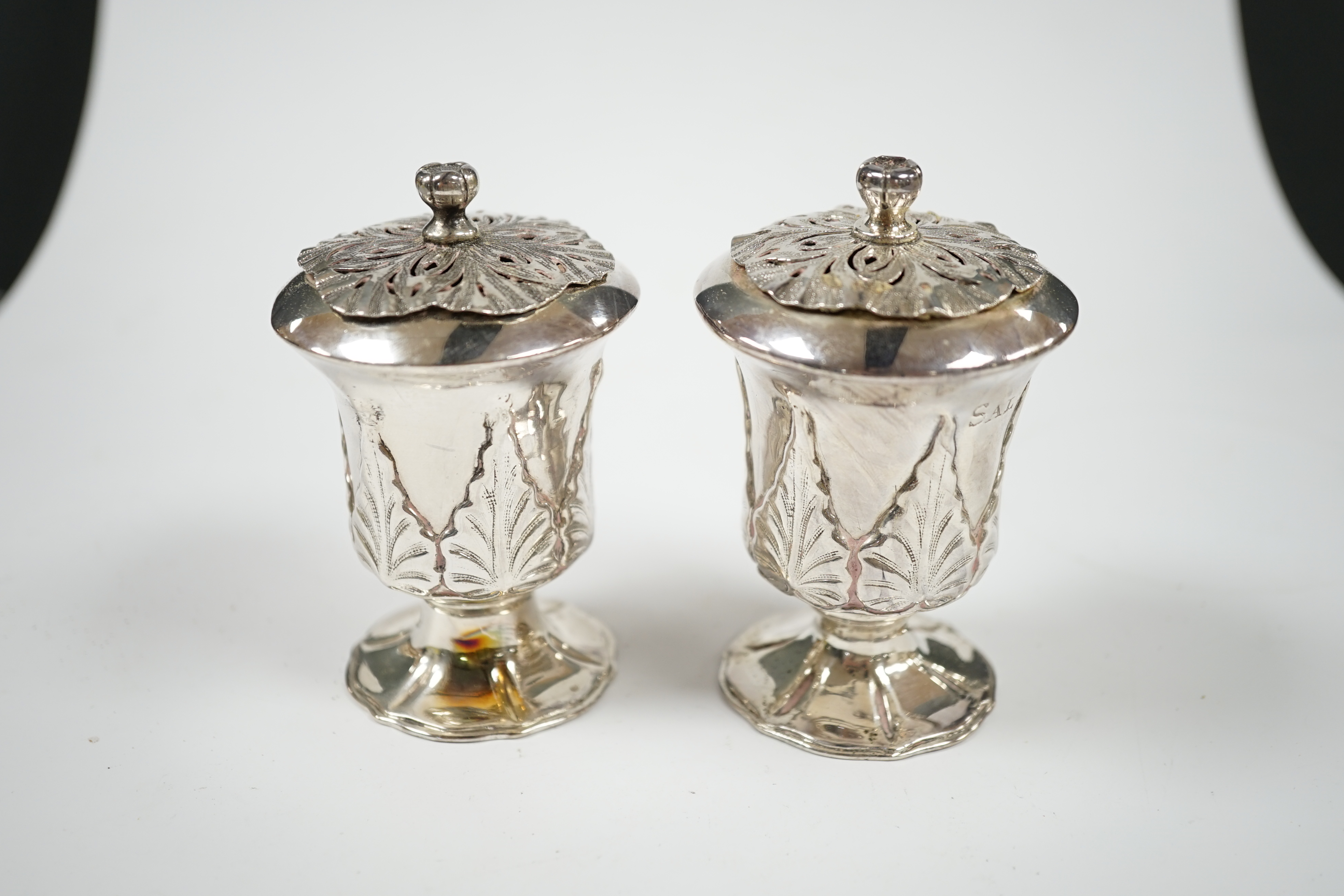 A pair of Indian? white metal condiments by Lattey Brothers & Co?, with acanthus leaf decoration, 83mm. Condition - fair